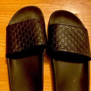 Black Gucci slides.